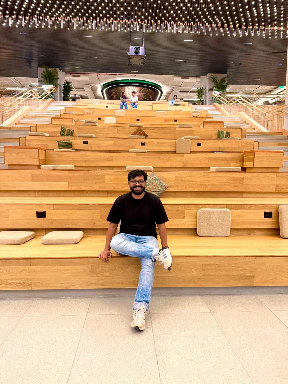 Shishir sitting in a wooden amphitheatre at a startup workspace
